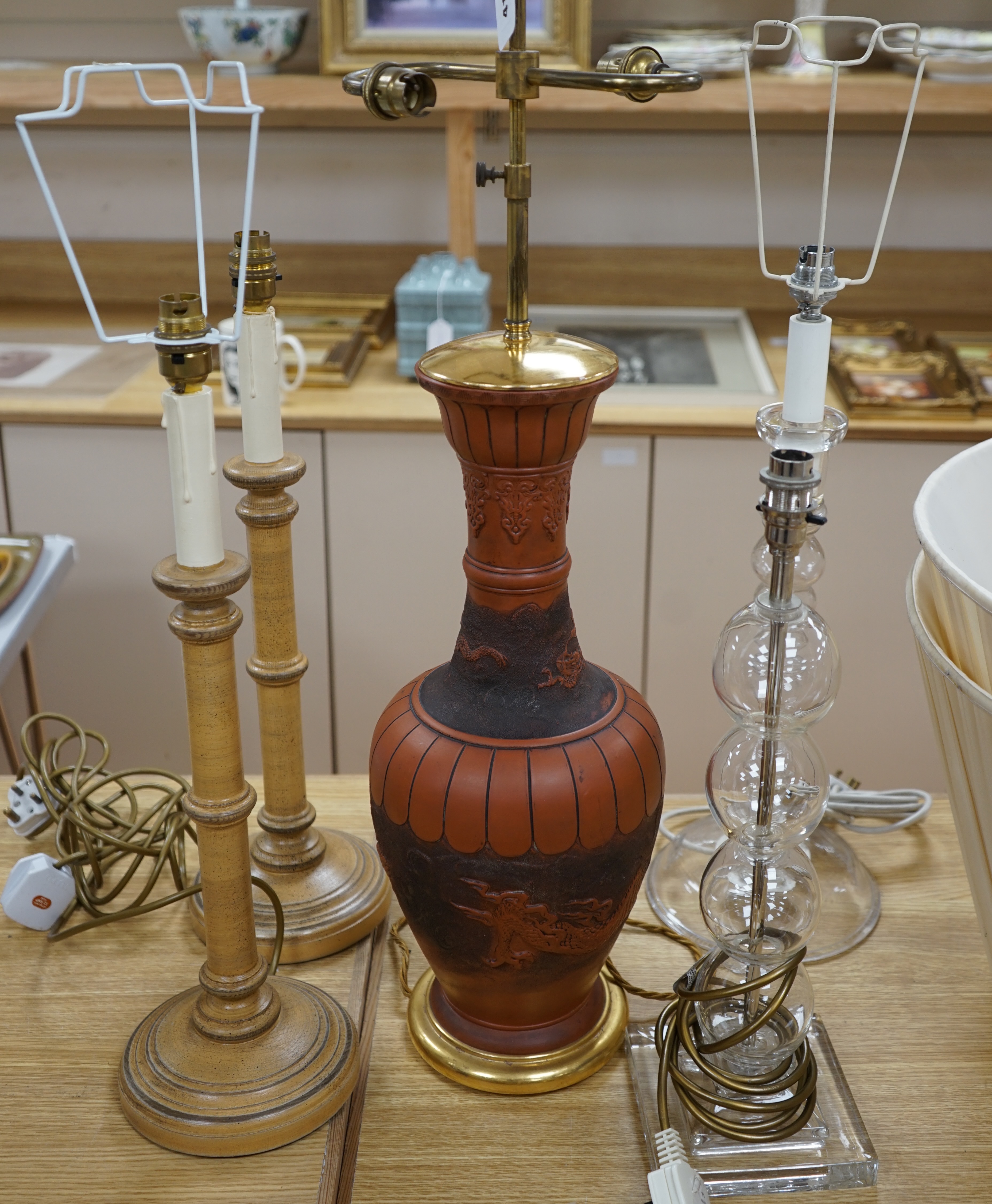 A Japanese terracotta dragon lamp base, two glass and a pair of wooden candlestick lamp bases, tallest 77cm high including light fitting (5). Condition - fair to good